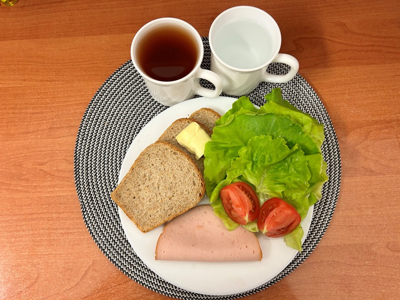 Herbata czarna ekspresowa z cytryną Cateringowa, Chleb Graham, Masło extra 82%, Filet zapiekany drobiowy, Pomidor, Sałata zielona, Woda mineralna niegazowana